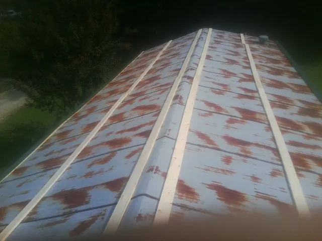 Rusted metal roof panels with new wood purlins before replacement — Storm Damage Roof Repair in Normal by Roofing Brothers